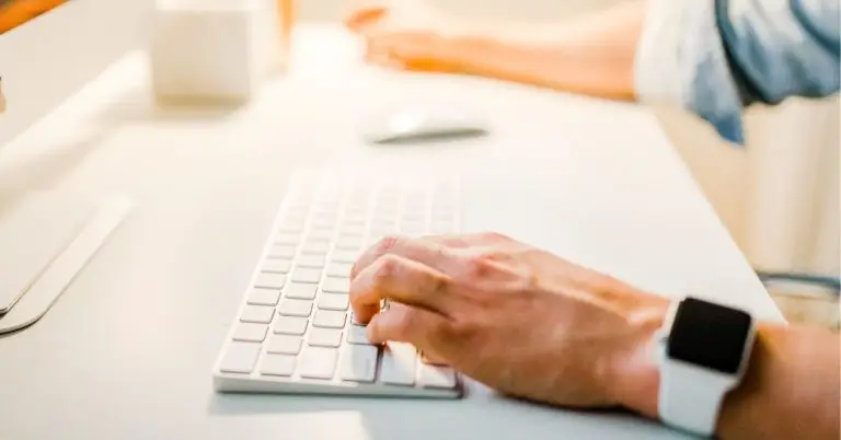 person typing on a keyboard in front of a monitor