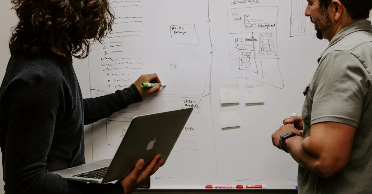 two people planning on a whiteboard