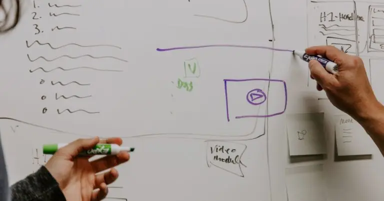 two people strategizing on a whiteboard