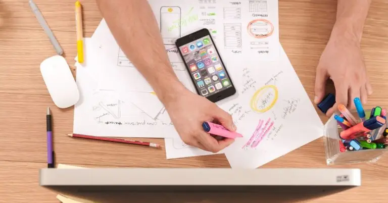 workspace with lots of drawing and writing materials and a computer