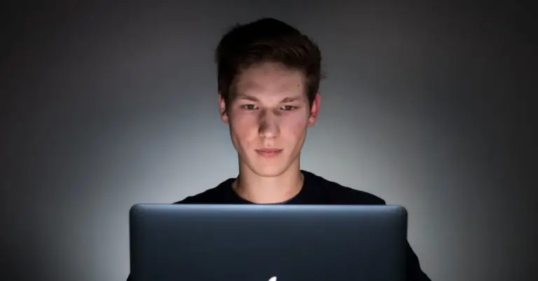 man sitting with a laptop on front of him
