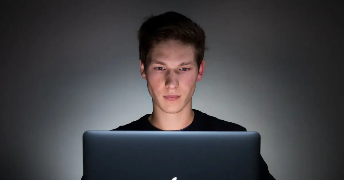 man sitting with a laptop on front of him