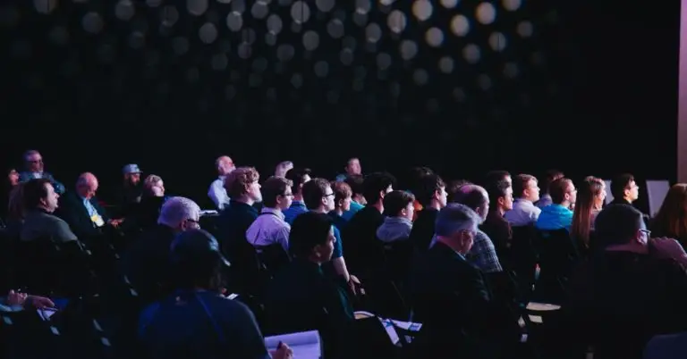 dark room with an audience sitting down