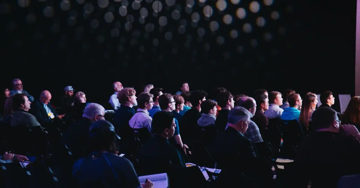 dark room with an audience sitting down